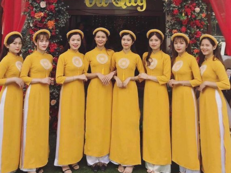 Áo dài vàng được yêu thích nhất cho đội bưng quả, tươi tắn, bắt sáng mà không lấn át cô dâu. Vàng trơn hay họa tiết nhẹ, lụa mềm mại giúp các cô duyên dáng, thanh thoát ngày trọng đại.